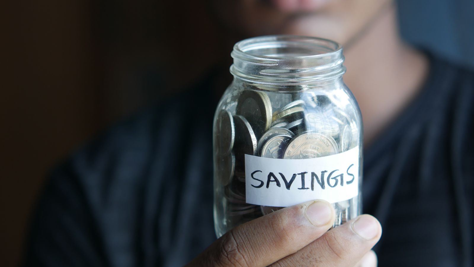 Coins stacked beside a savings jar